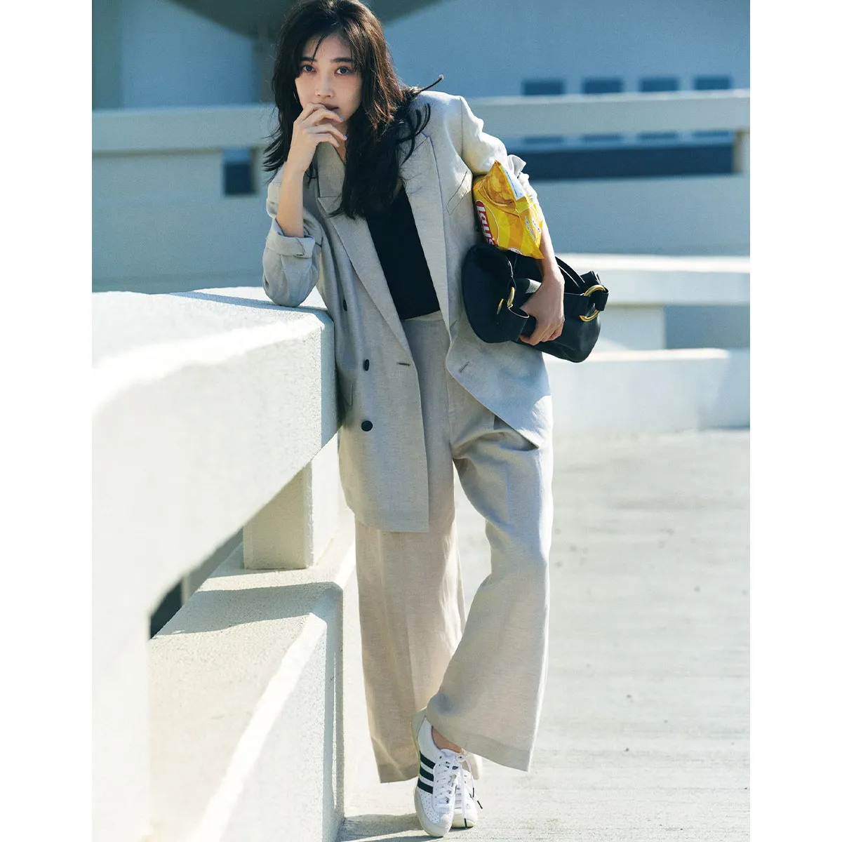 オフィスカジュアルにおすすめのグレーのセットアップ×白スニーカーの林田岬優さん