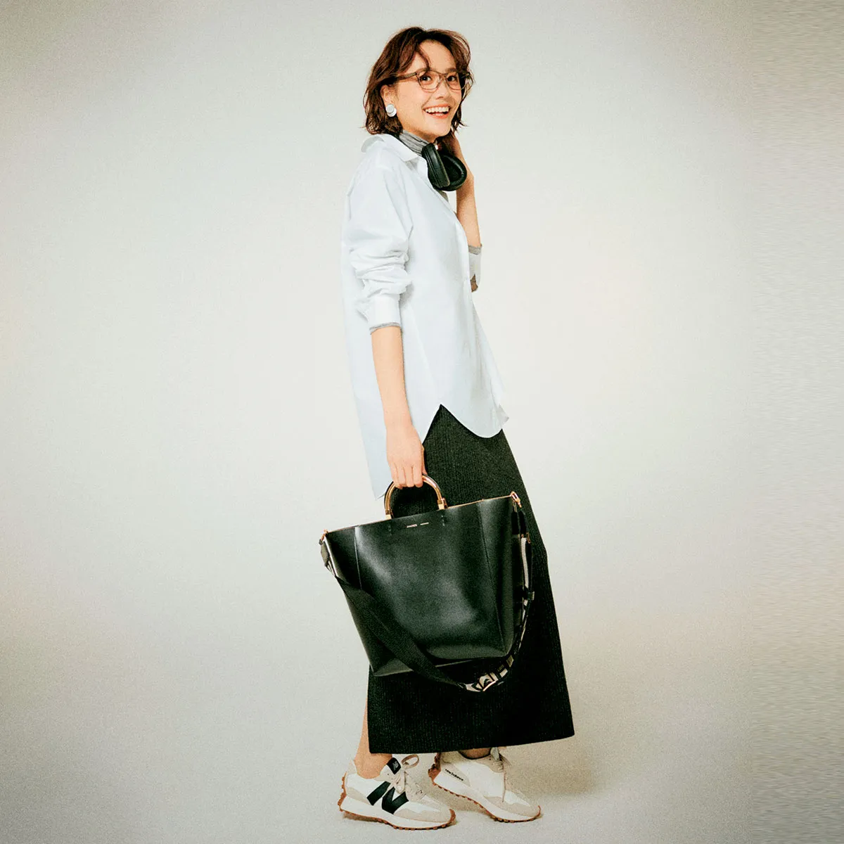 オフィスカジュアルにおすすめの白シャツ×黒リブニットスカート×白スニーカーの松井愛莉さん